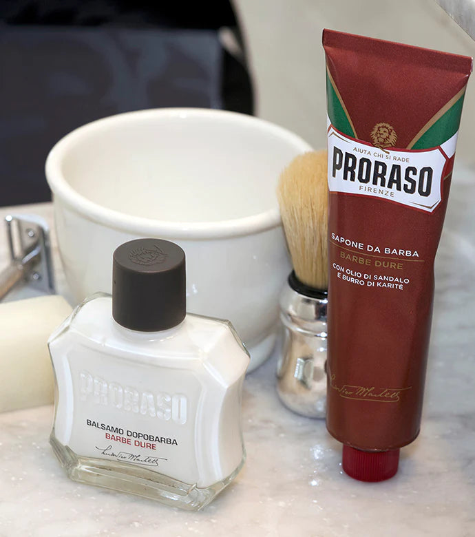 Products sitting on the bathroom counter Proraso Post-Shave Stone, Coarse Beard After Shave Balm, Professional Shaving Brush and Coarse Beard Shaving Cream Tube