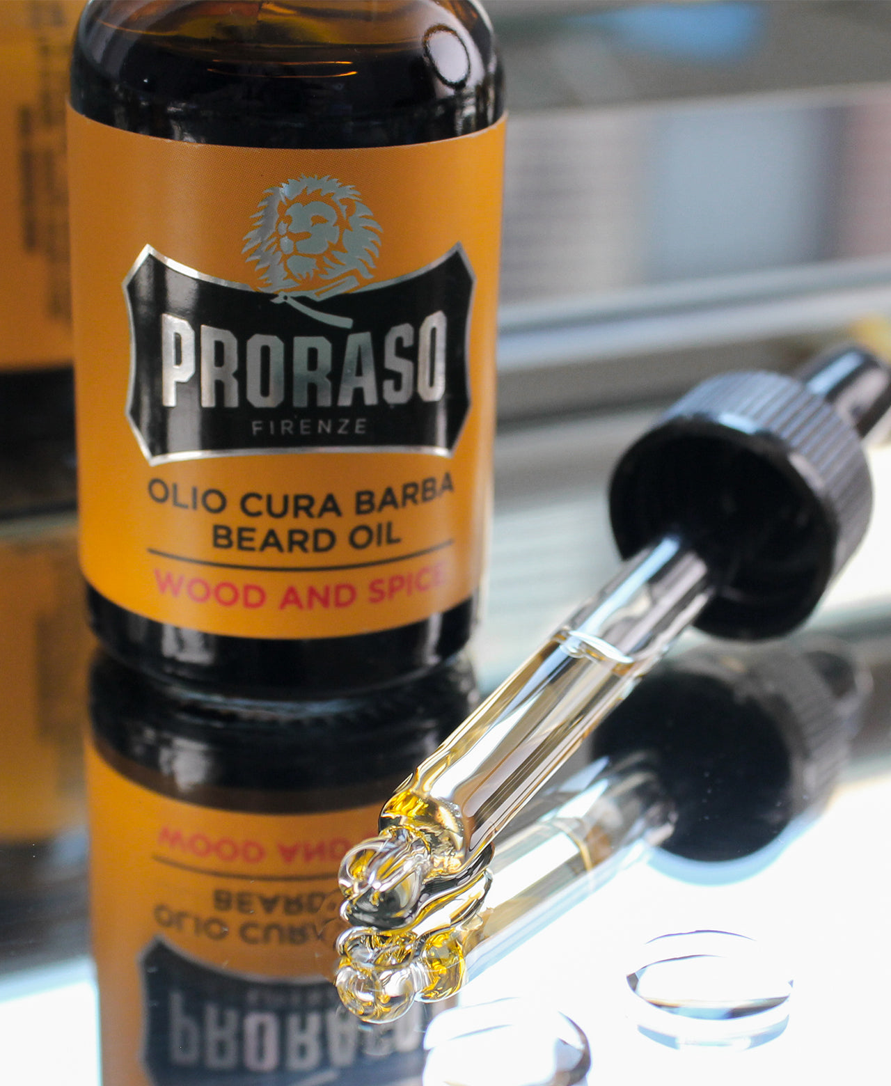 Wood & Spice Beard Oil bottle with dropper sitting on top of mirror with visible drops and oil in vial