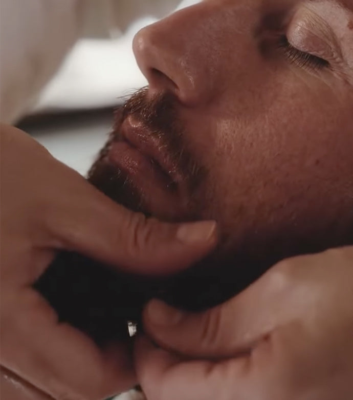 Beard Oil being applied by a barber to a man with a medium length beard