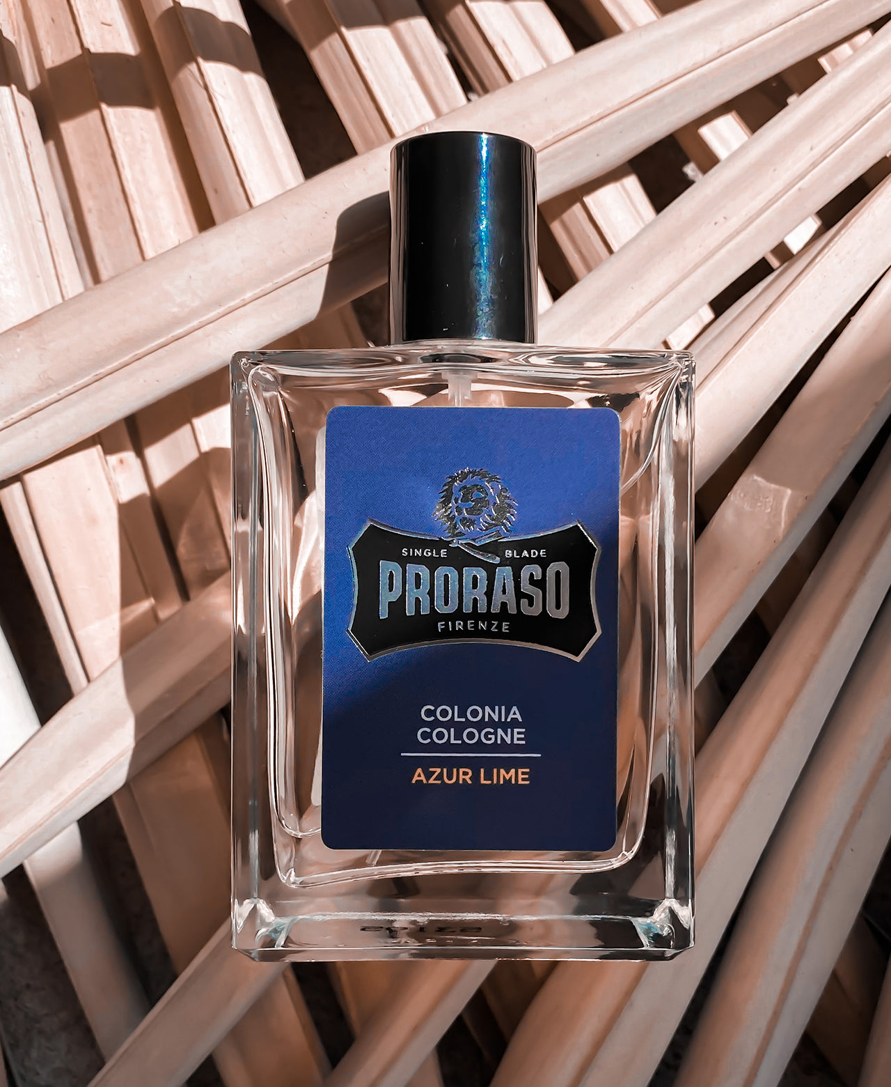 Azur Lime Cologne sitting on top of light brown palm fronds 