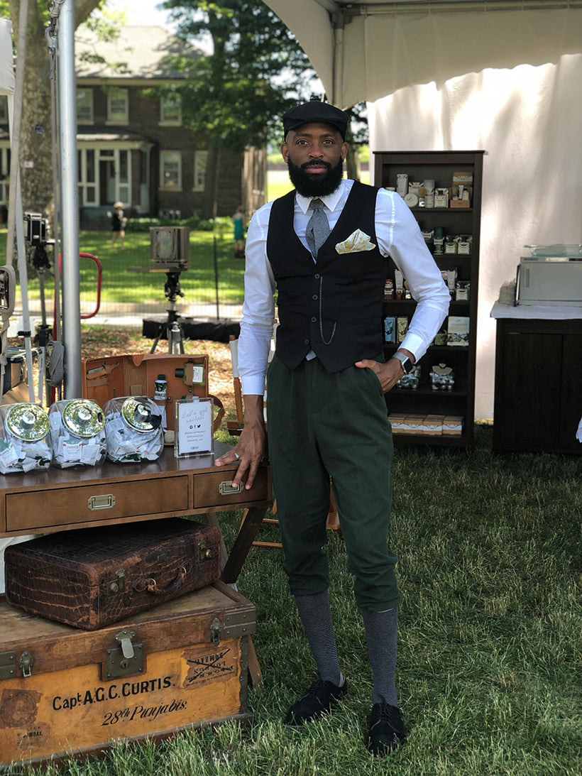 Marko dressed in vintage clothing posing for the camera in the Proraso mobile barbershop