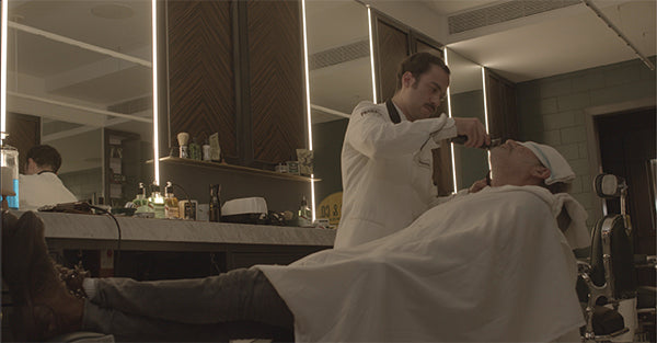 Proraso Master Barber giving Frank a beard trim who is reclined in a barber chair