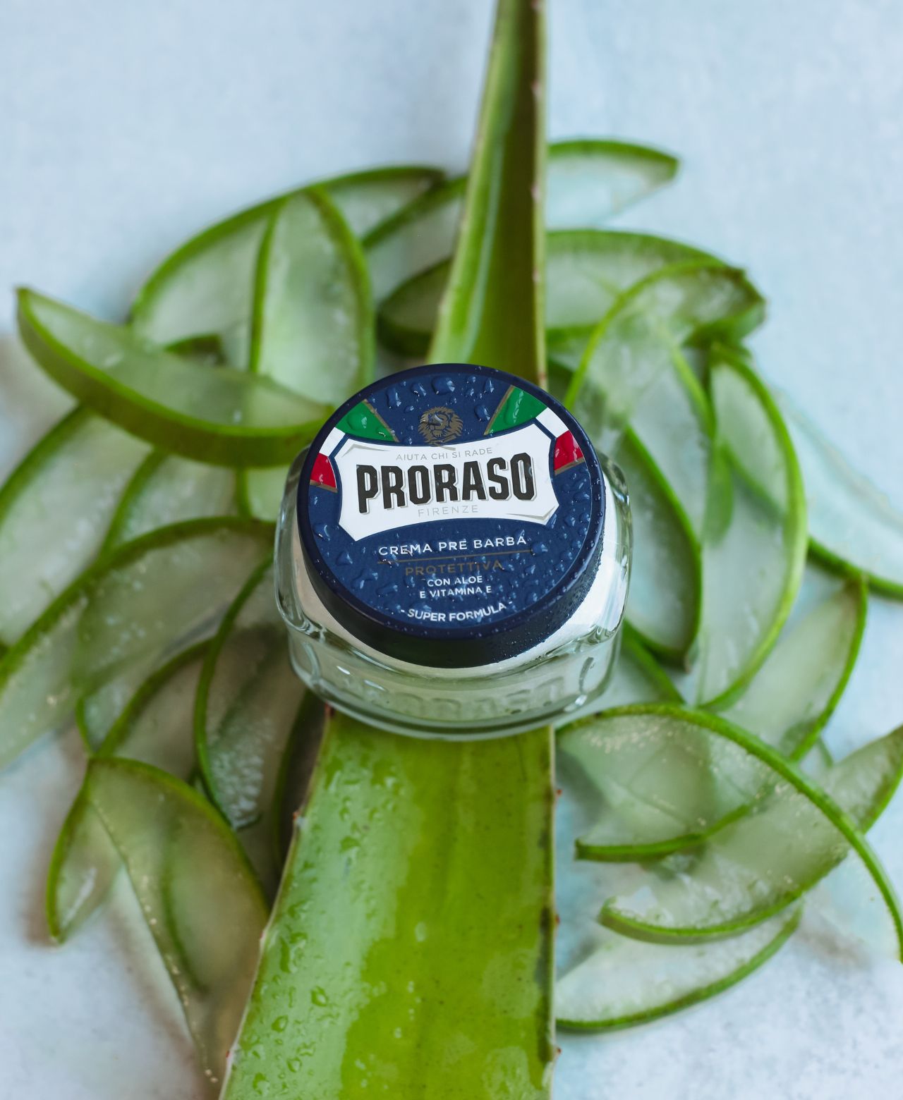 Jar of Protective Pre-Shave Cream sitting on slices of Aloe Vera