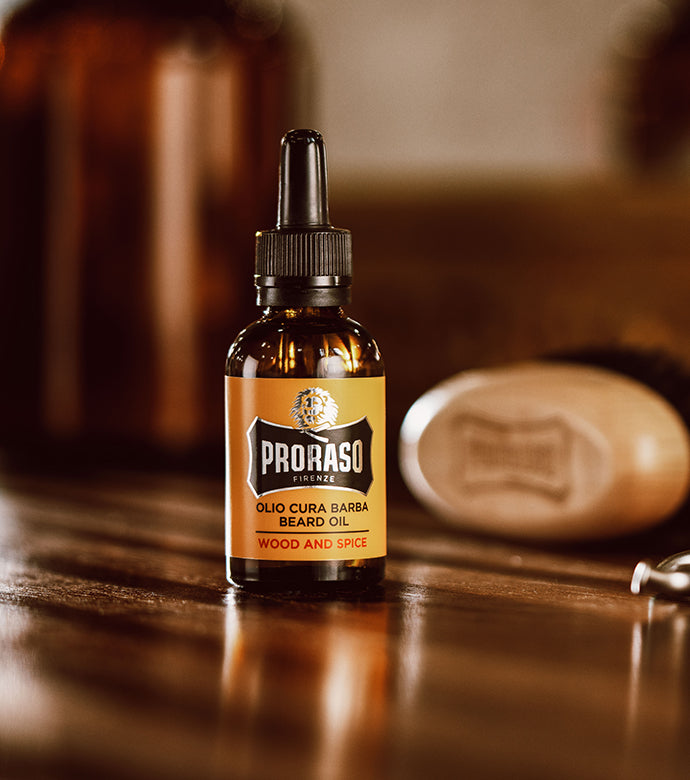 Wood & Spice Beard Oil sitting on dark wood counter with a Beard and Moustache brush in the background 