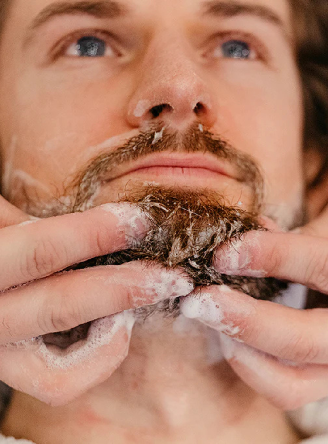 Man getting his beard washed by a barber