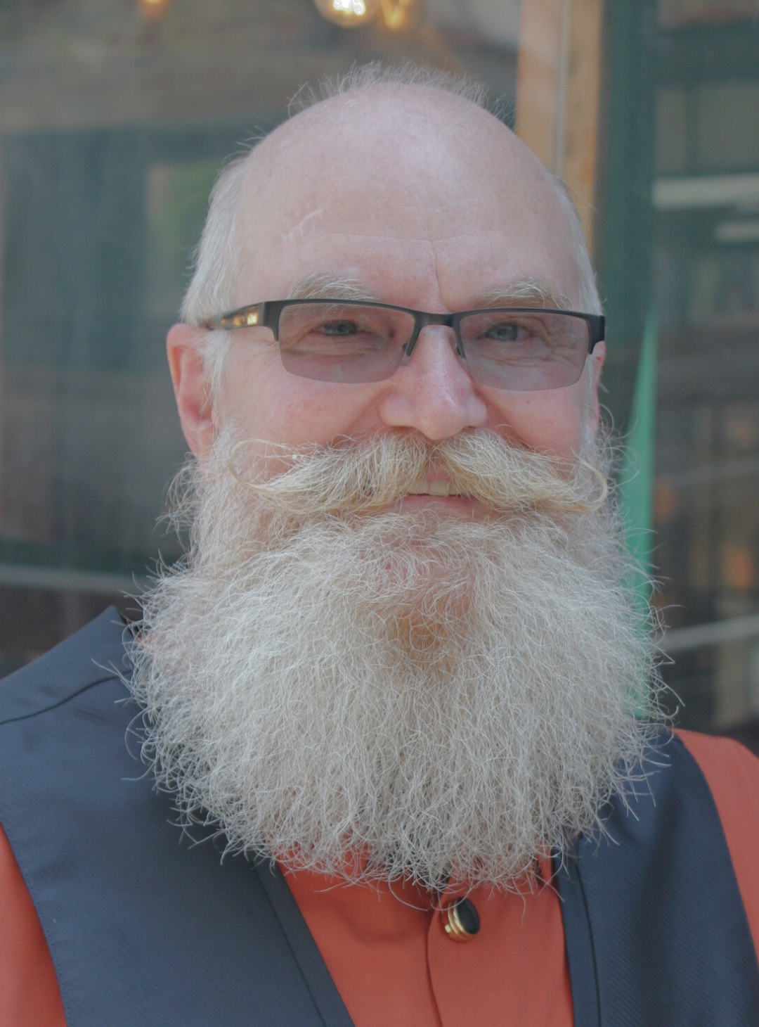 Man with long, thick beard wearing glasses