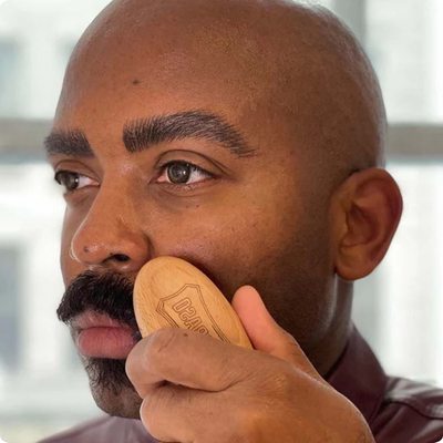 Man using our Moustache & Beard Brush to clean up his moustache